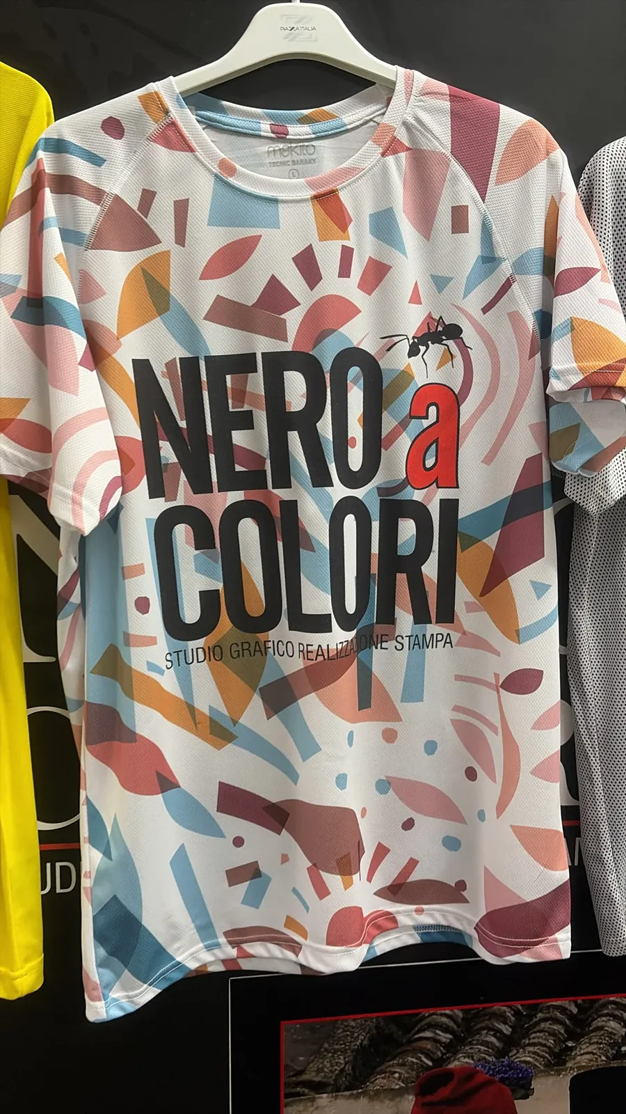 T-shirt tecnica con stampa integrale a fantasia geometrica e logo NERO a COLORI